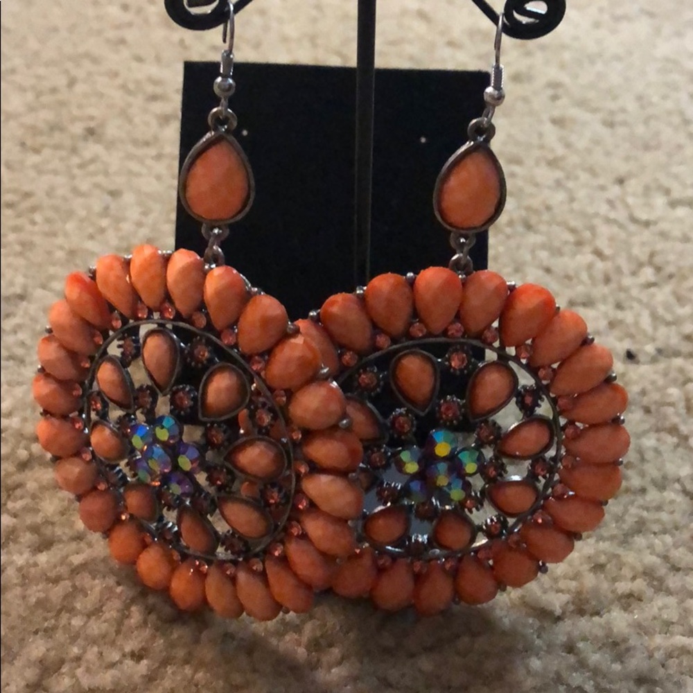 Huge coral jeweled earrings.